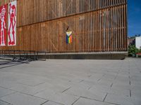 a group of people riding skateboards near wooden panels and stairss with artwork on them