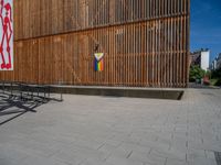 a group of people riding skateboards near wooden panels and stairss with artwork on them