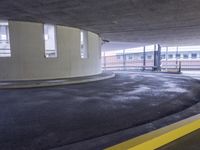 a car parked inside of a parking garage underpasss with a bench near the road