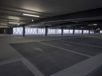 an empty parking lot with a lot of parking spaces on the floor, near large windows