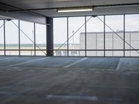 an empty parking lot with a lot of parking spaces on the floor, near large windows