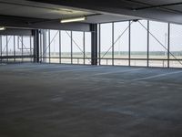 an empty parking lot with a lot of parking spaces on the floor, near large windows
