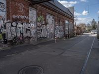 an empty street is covered in graffiti next to a building and tram tracks with a sign reading,