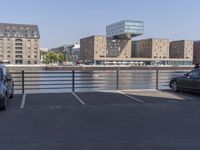 car park with view over bridge and buildings in urban area on clear day, day