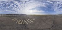 an empty runway with a circular reflection of clouds and a sky that looks like it is upside down