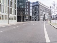 an empty road between two buildings on a busy city street in the city, some people are walking down the street