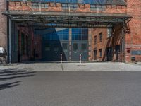 the empty street with white poles is empty and there are no traffic signs in the shot