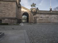 an outdoor courtyard with a statue and a clock tower on top of it as well