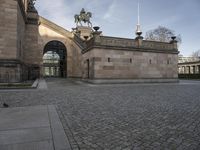 an outdoor courtyard with a statue and a clock tower on top of it as well