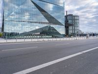 the modern building is reflected in the glass front of the building's exterior and road