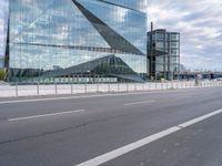 the modern building is reflected in the glass front of the building's exterior and road