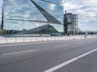 the modern building is reflected in the glass front of the building's exterior and road