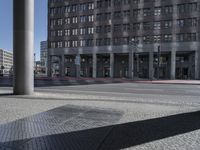 a city street with concrete columns and high rise buildings and blue skies above the area