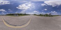 a street intersection with the same markings on it and a sky background with fluffy white clouds