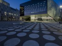 the exterior of a building has circles on it as it sits next to other buildings