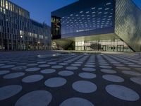 the exterior of a building has circles on it as it sits next to other buildings