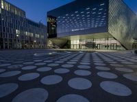 the exterior of a building has circles on it as it sits next to other buildings