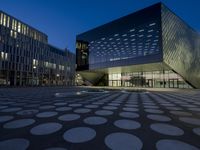 the exterior of a building has circles on it as it sits next to other buildings