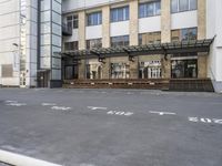 an empty building with signs on the street and people on bikes in traffic passing by