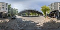 an empty circular road in a european city with a bike lane and an archway across the middle