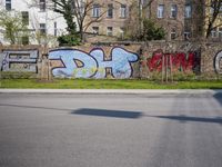 a fence with several graffiti art on it, with the word fes painted in red and purple