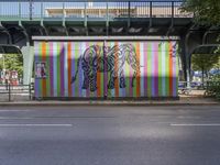 a brightly colored mural with an elephant and a zebra on a wall at a city street