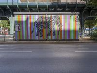 a brightly colored mural with an elephant and a zebra on a wall at a city street