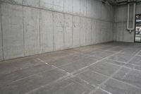 an empty warehouse space with a fire hydrant next to the large wall of cement