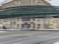 this person is riding a bike underneath an overhead bridge in the city on a snowy day