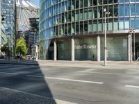 a large building on the corner of an intersection in city with cars on the sidewalk