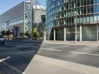 a large building on the corner of an intersection in city with cars on the sidewalk