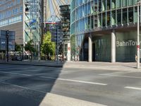 a large building on the corner of an intersection in city with cars on the sidewalk