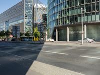 a large building on the corner of an intersection in city with cars on the sidewalk