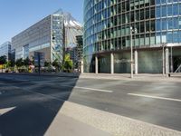 a large building on the corner of an intersection in city with cars on the sidewalk