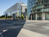 a large building on the corner of an intersection in city with cars on the sidewalk