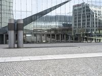 a person sitting on the ground near a large glass building with a black nike logo