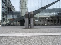 a person sitting on the ground near a large glass building with a black nike logo