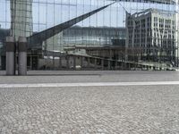 a person sitting on the ground near a large glass building with a black nike logo