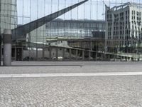 a person sitting on the ground near a large glass building with a black nike logo