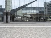 a person sitting on the ground near a large glass building with a black nike logo