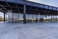 there is a large, empty outdoor covered building that features glass doors and a roof