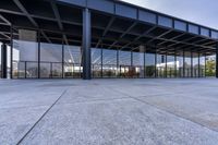 there is a large, empty outdoor covered building that features glass doors and a roof