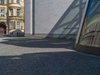 Berlin's Glass Walls and Hard Shadows on Cobblestone Streets