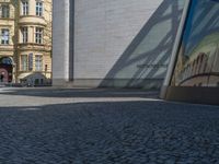 Berlin's Glass Walls and Hard Shadows on Cobblestone Streets