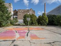 the cross on the asphalt is drawn with colorful chalk and paint from a paint spray