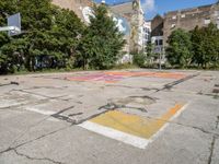 an empty basketball court has graffiti painted on it in the middle of a city sidewalk