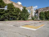 an empty basketball court has graffiti painted on it in the middle of a city sidewalk