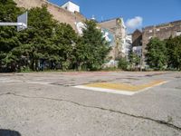 an empty basketball court has graffiti painted on it in the middle of a city sidewalk