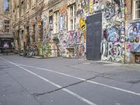 a bike parked in the middle of the street in front of some buildings covered in graffiti