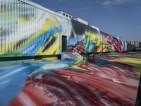 this is a graffiti - covered building that is painted on the wall is white, green and blue